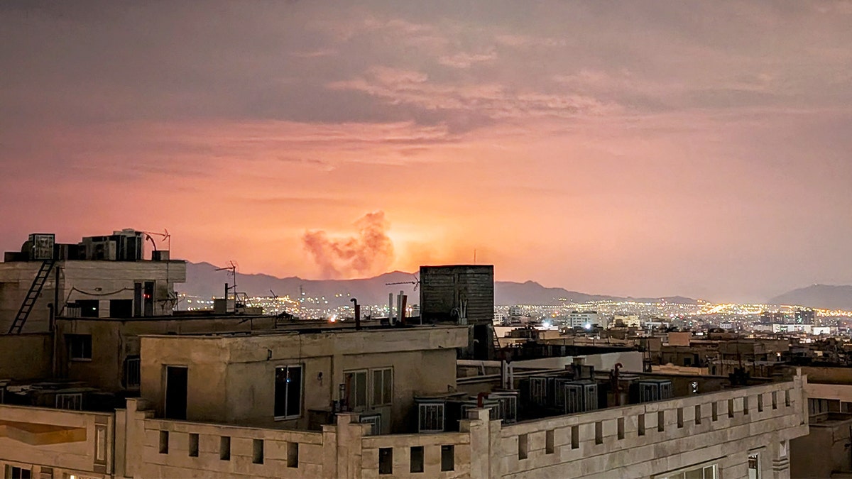 Thick columns of smoke billow above buildings in Tehran after explosions rocked the city.